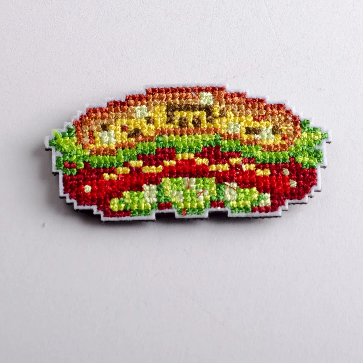 Product 12 embroidered garment badge under a thread-detail magnifier