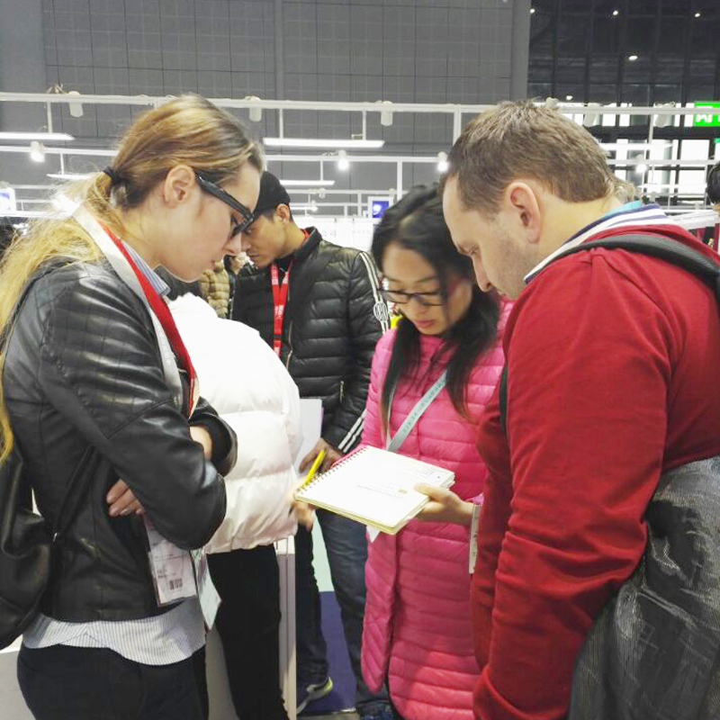 Teebling team discussing a wholesale apparel brief with exhibition visitors
