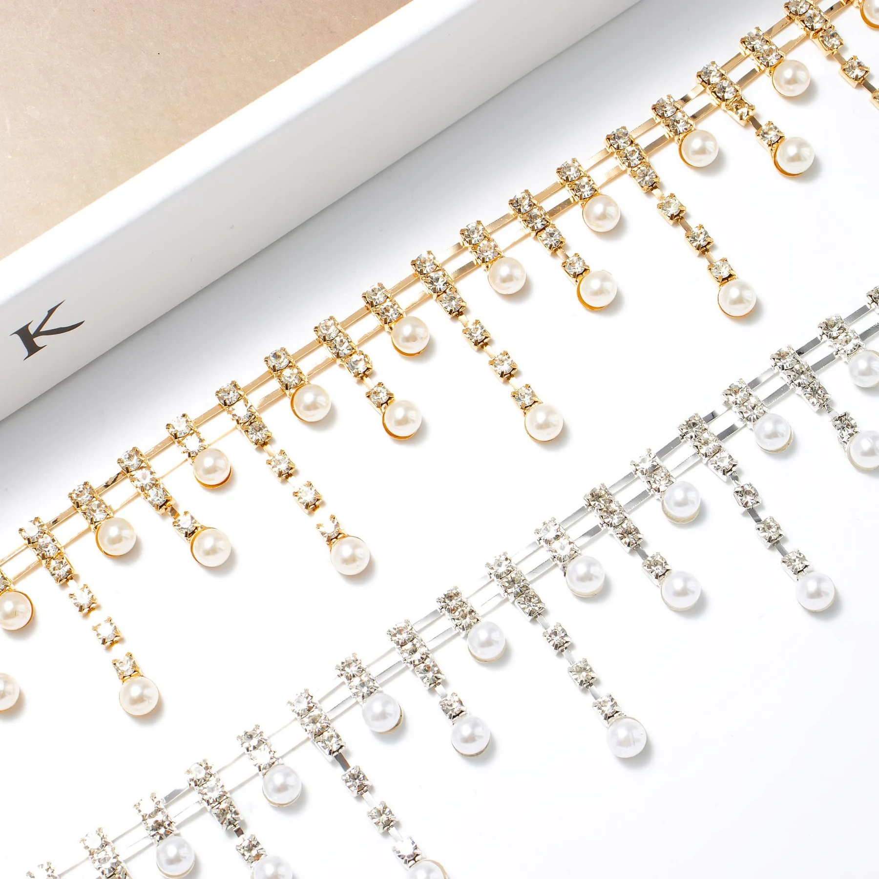 Double-row rhinestone fringe with graduating pearl-look drops in silver and champagne gold