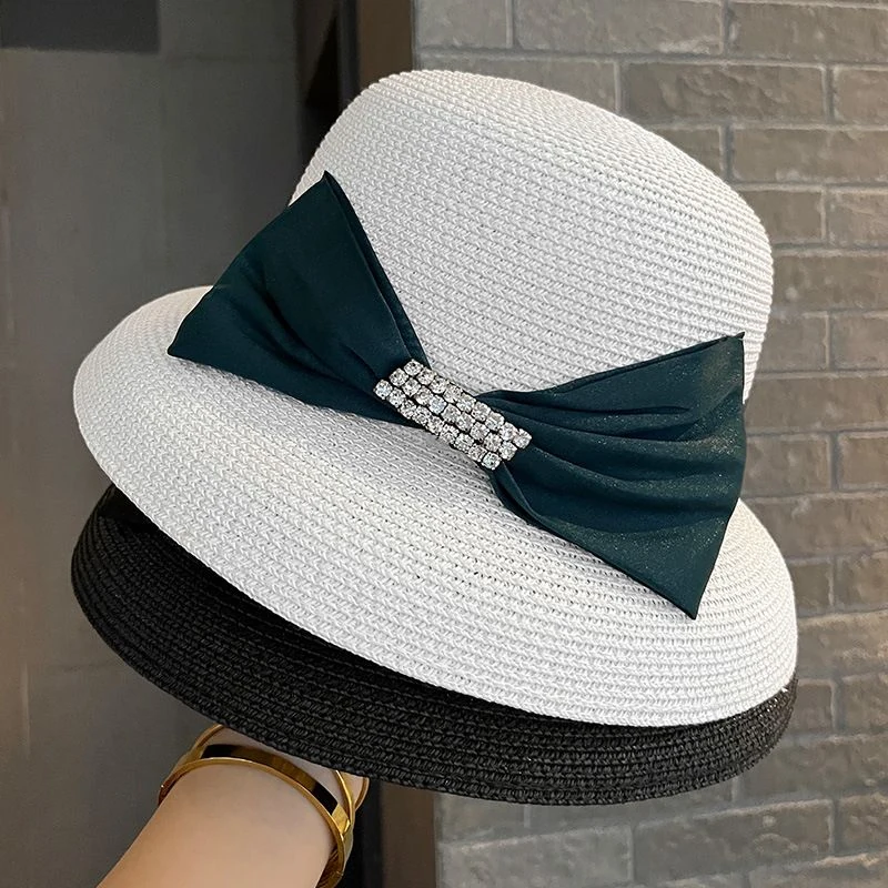 Women's woven straw-look sun hat with large bow and rhinestone buckle